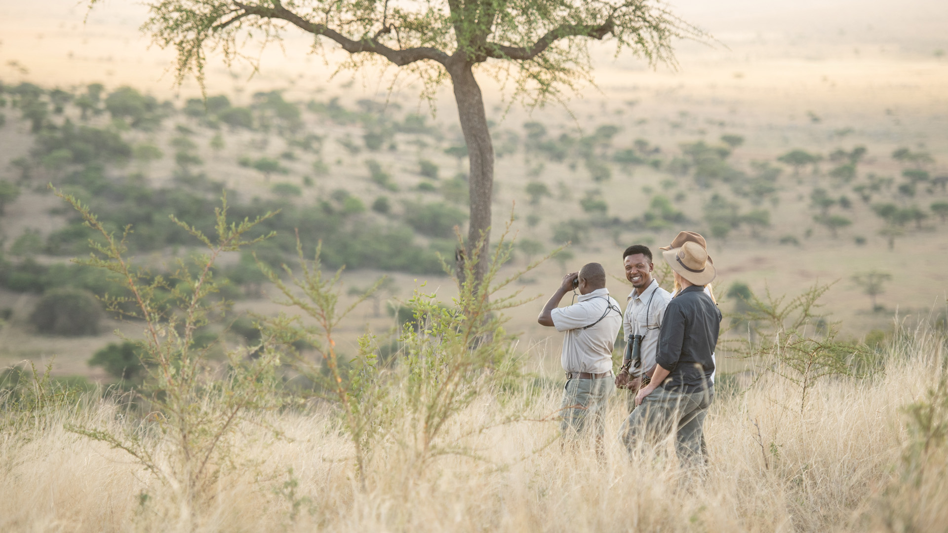 Travellers with their guide on the savannah of Grumeti Game Reserve at Singita in Tanzania